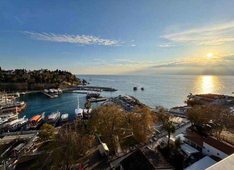 A coastal town with a marina, boats, and a sunset over the water. 5