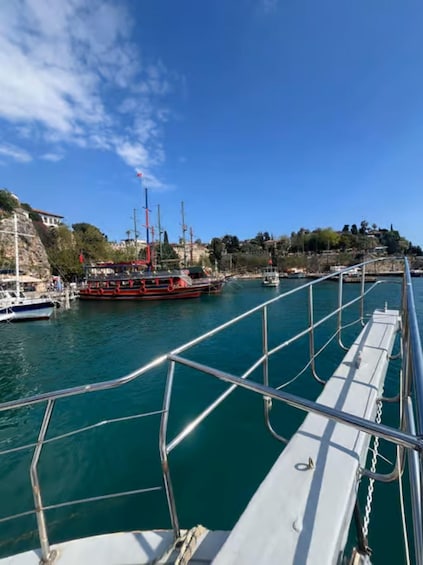 A harbor with a large red and white ship docked, calm water, and a clear blue sky. 3
