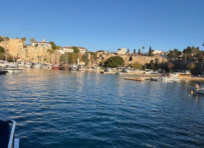 A coastal town with historic buildings, a rocky shoreline, and boats in the water. 1
