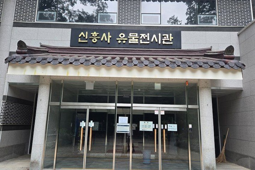 A traditional Korean building with a tiled roof and a sign in Korean. 3
