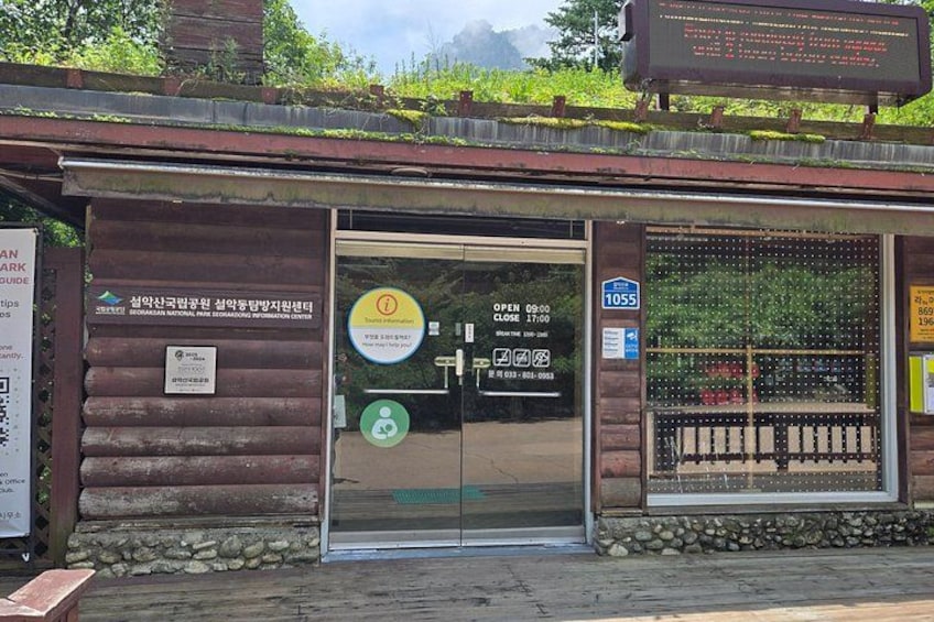 A wooden building with a glass door, a signboard, and a stone pathway. 5