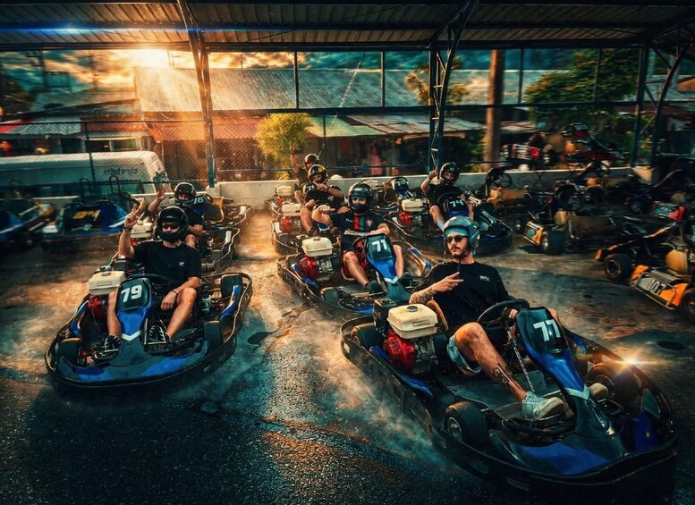A go-kart racing track with multiple go-karts and drivers. 1