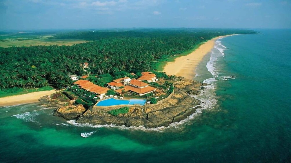 A tropical island with a beach, a swimming pool, and lush greenery. 4