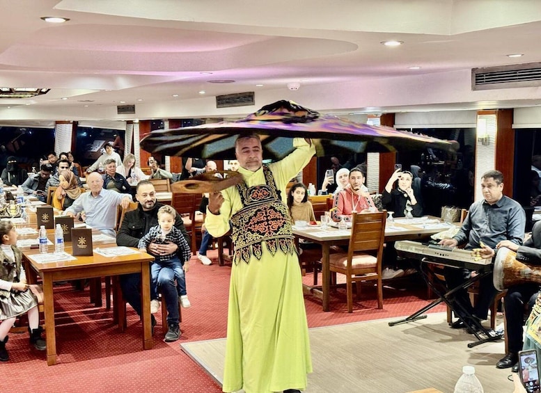 A person performing with a colorful object in a room with seated people. 3
