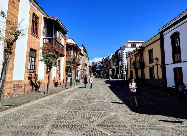 A cobblestone street lined with historic buildings, some with balconies and others with large windows. 4