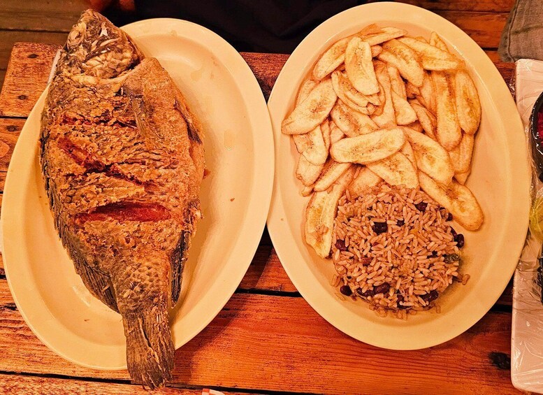 A whole fried fish and a plate with fries and rice. 5
