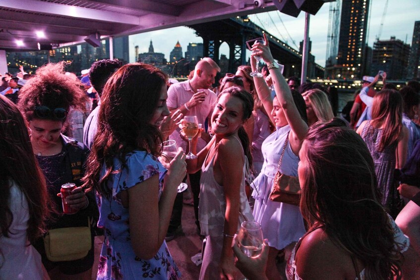 A group of people at a rooftop bar with a city skyline in the background. 2
