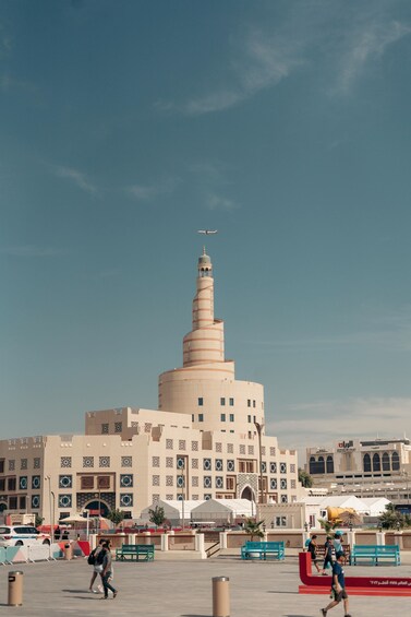 A large spiral minaret and a modern building with intricate designs. 3