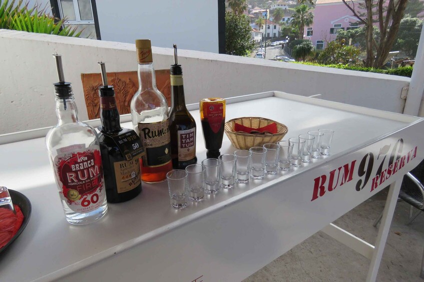 A bar with various bottles of rum and shot glasses on a table. 4