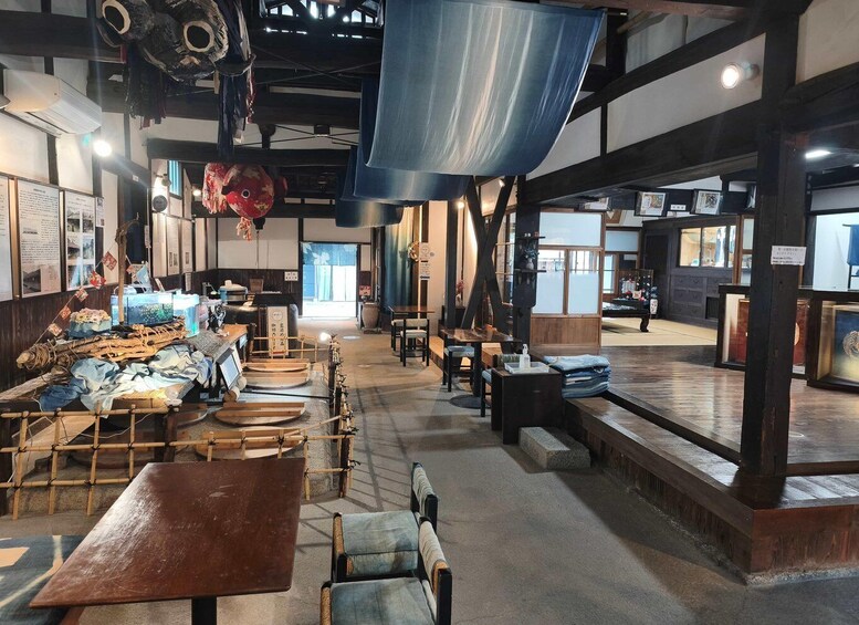 A traditional Japanese restaurant interior with tatami mats, wooden furniture, and a sushi display. 5