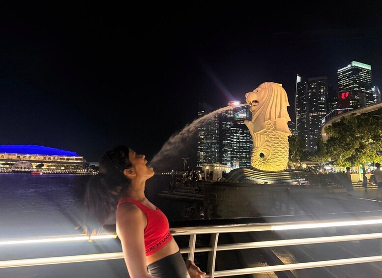 A person spraying water from a fountain towards a statue. 4