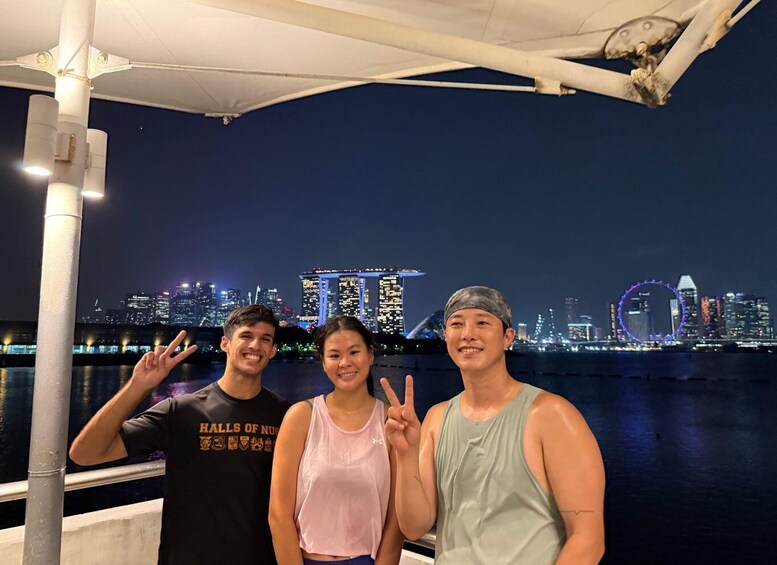 Three people posing with a city skyline in the background. 2