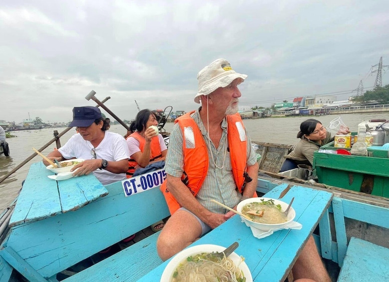People on a boat eating food, wearing life jackets, and a sign with CT-00075. 4