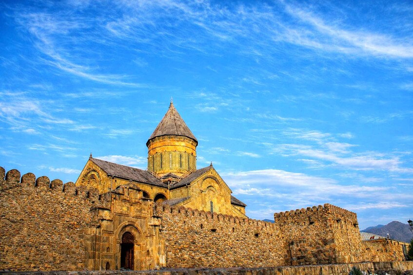 A historic stone fortress with a prominent tower and arched entrance. 4