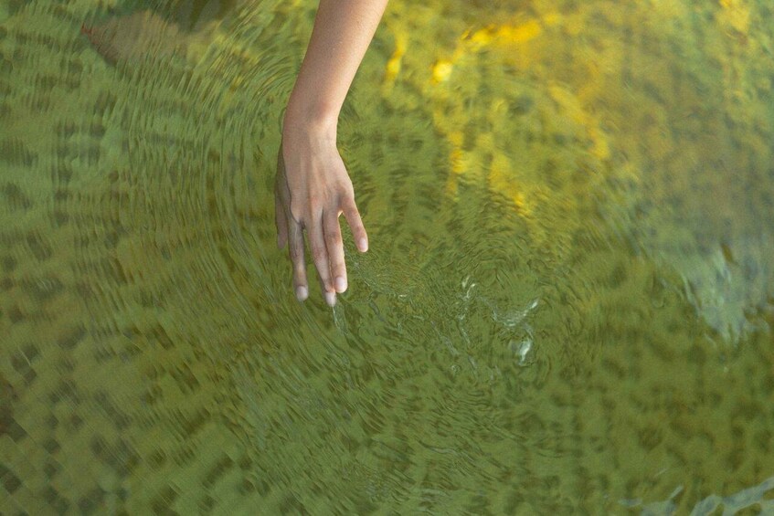 A hand touching a textured surface with a pattern of raised dots. 4