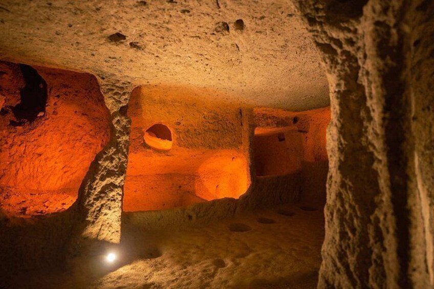 A cave interior with rock formations and a light source. 3