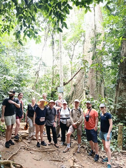 A group of people in a forested area with trees and a dirt path. 5