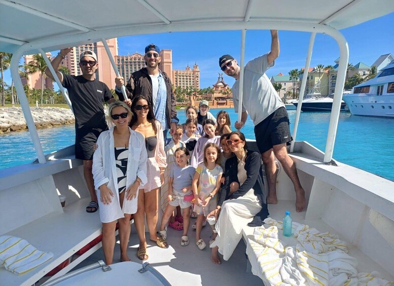 A group of people on a boat with a view of a large hotel and palm trees. 3