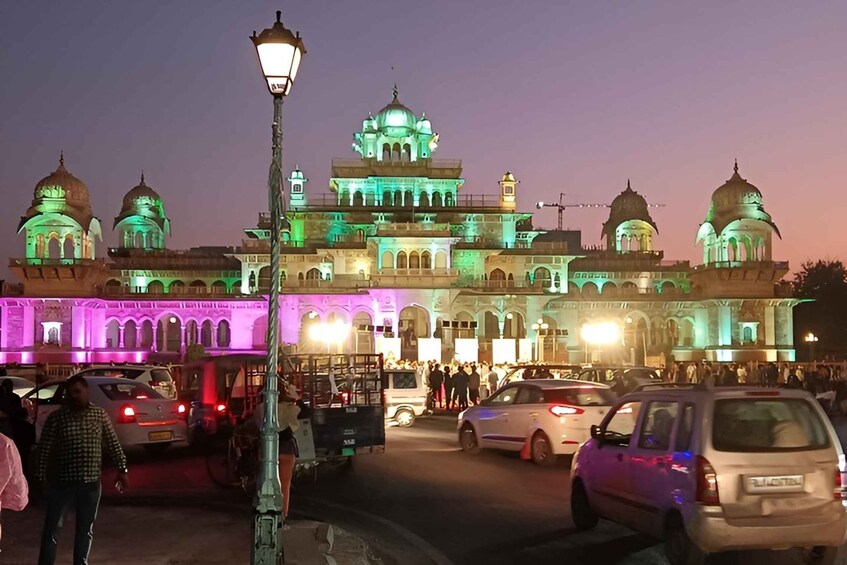 A historic building with domes and arches, illuminated at dusk. 5