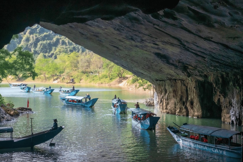 A cave opening over a river with boats. 5