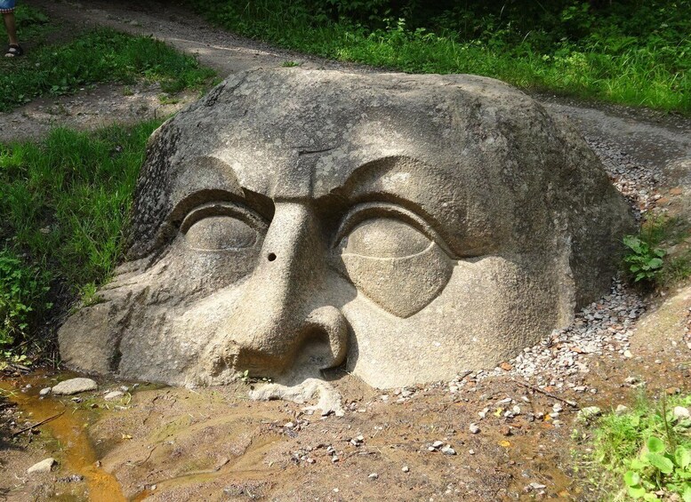 A large stone face with a nose and mouth carved into a rock. 2