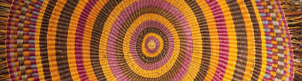 A circular woven textile with concentric stripes in various colors. 2