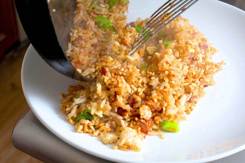 A plate of fried rice with visible ingredients like green onions and red peppers. 3