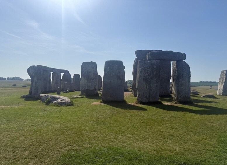 Stonehenge standing in a grassy field under a clear sky. 5