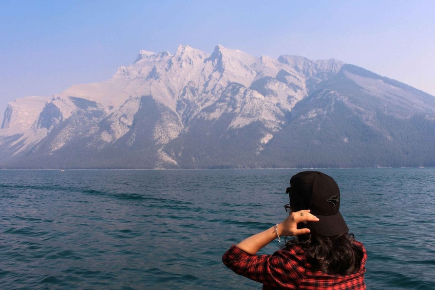 A person taking a photo of a mountain range by a lake. 5