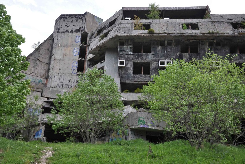 A dilapidated building with graffiti and overgrown vegetation. 4