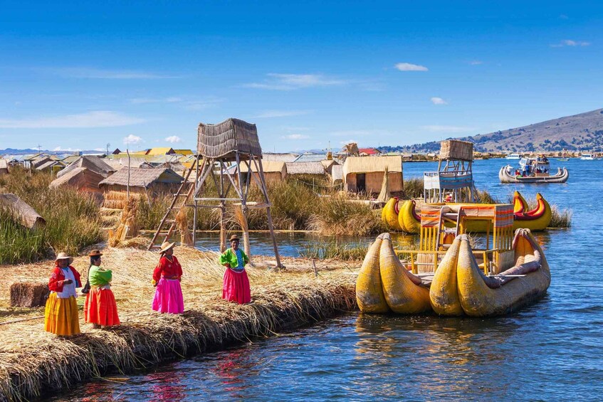 A traditional floating village with people in colorful attire, a wooden structure, and canoes on the water. 3