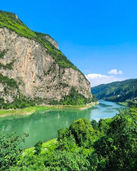 A river winding through a mountainous landscape with lush greenery and rocky cliffs. 2