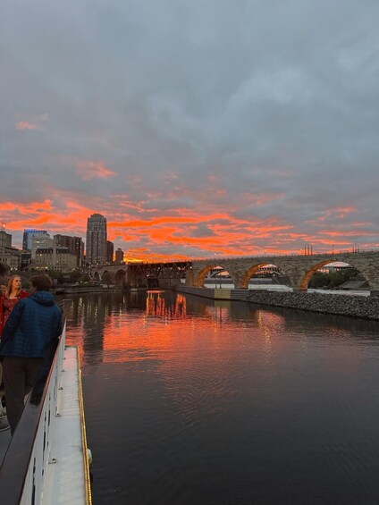 A sunset over a river with a bridge and city buildings in the background. 3