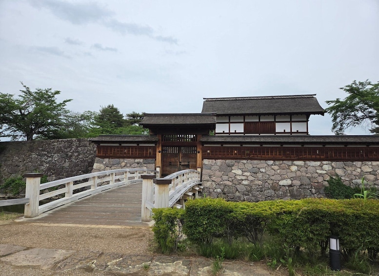 A traditional Japanese building with a wooden bridge leading to it. 2