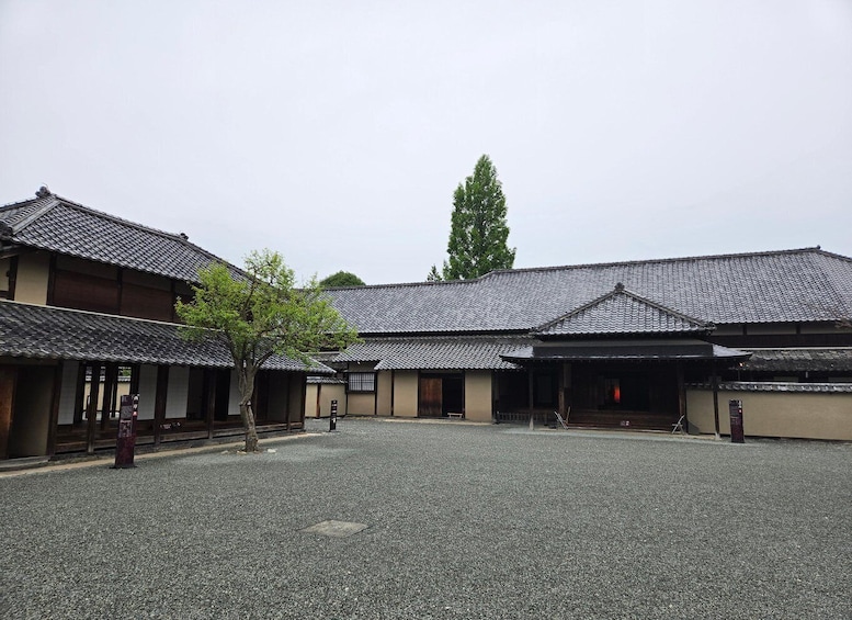 A traditional Japanese building with tiled roofs and a gravel courtyard. 4