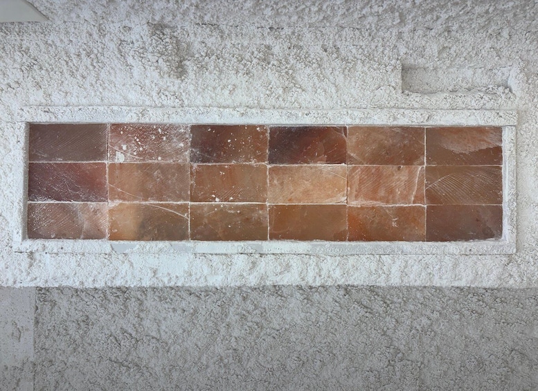 A rectangular tile wall with a mix of brown and beige tiles. 4