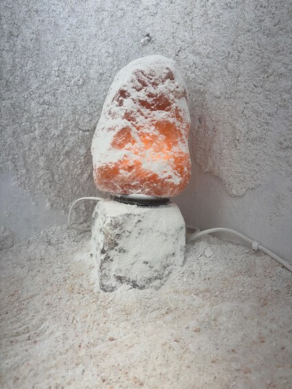 A salt lamp on a textured white wall. 5