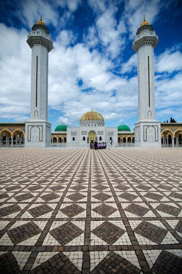 A large mosque with two minarets, a central dome, and a tiled courtyard. 3