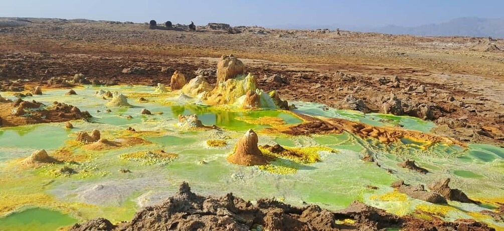 A geothermal landscape with mineral deposits and pools of water. 5