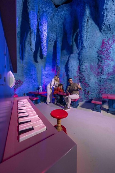 A family at a piano bar with a cave-like wall in the background. 5