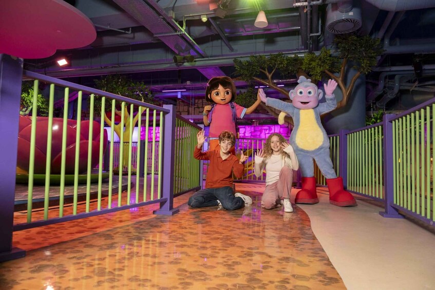 A play area with a large inflatable slide, a tree decoration, and a character mascot. 2