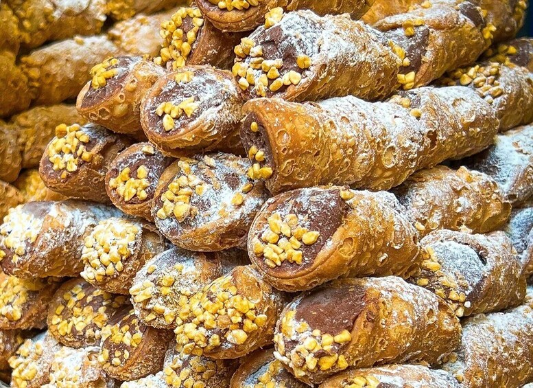 A stack of pastries dusted with powdered sugar and topped with chopped nuts. 2