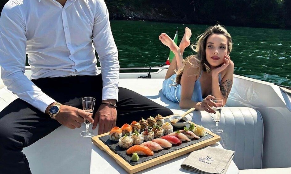 A boat with a dining table set with sushi and a glass of wine. 1