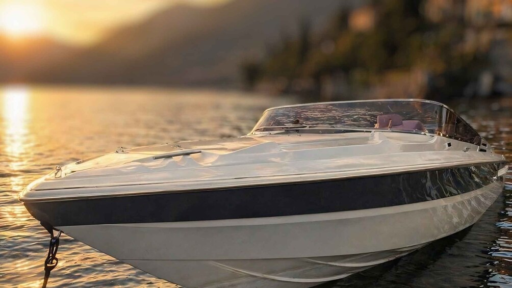 A speedboat docked at a pier with calm water and a sunset in the background. 5