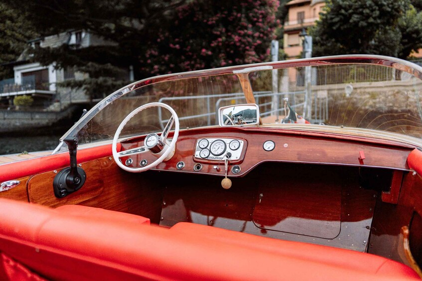 A vintage boat with a wooden interior and a steering wheel. 4