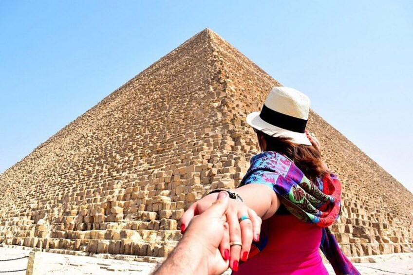 Una gran estructura piramidal con una persona en primer plano. 1