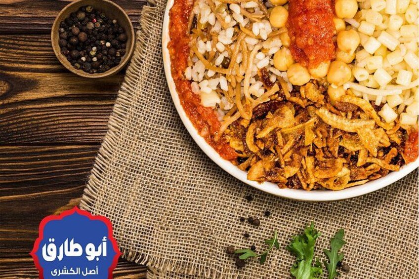 Un plato de comida con arroz, garbanzos, cebollas y salsa de tomate. 3