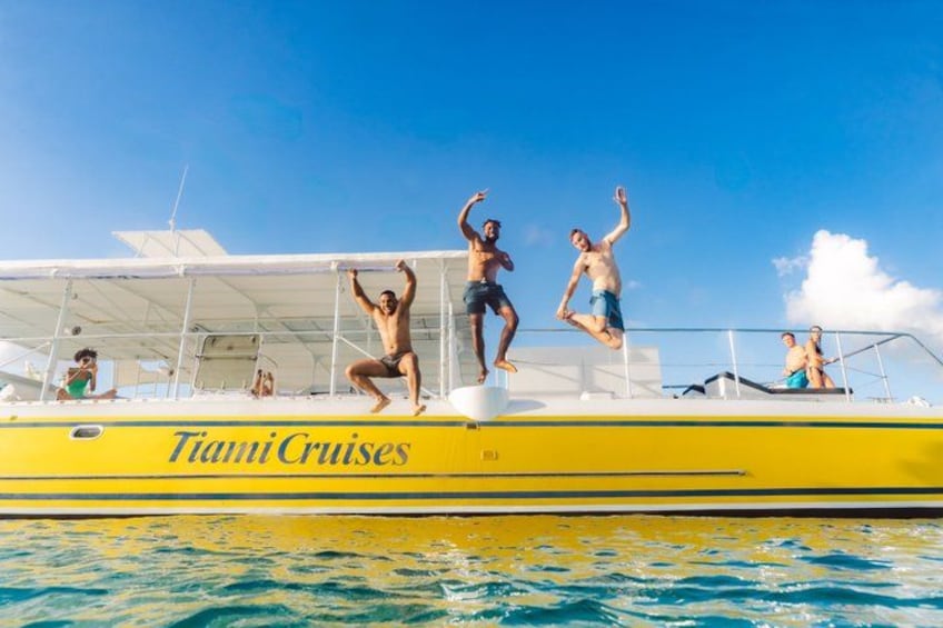A yellow boat with people jumping off the edge. 3