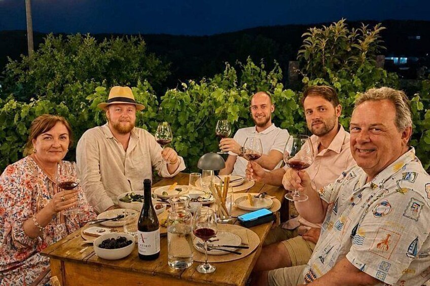 A group of people dining outdoors at night. 5