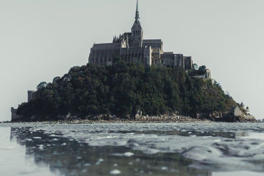 A castle on a small island surrounded by water. 5